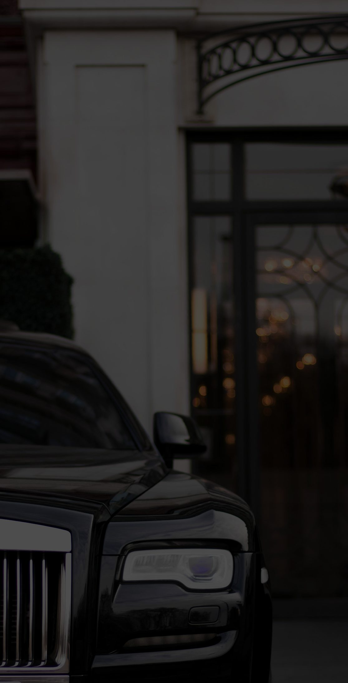 Private car waiting under the portico of a hotel entrance at night